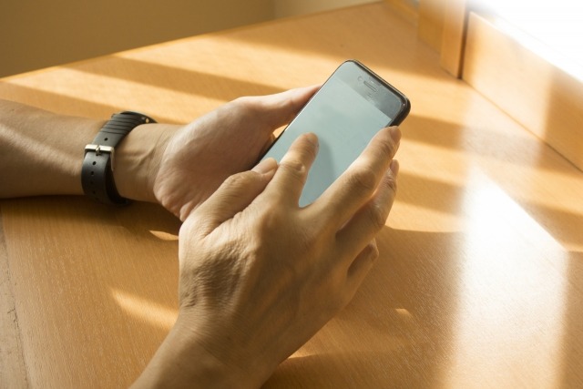 iPhoneを操作する男性